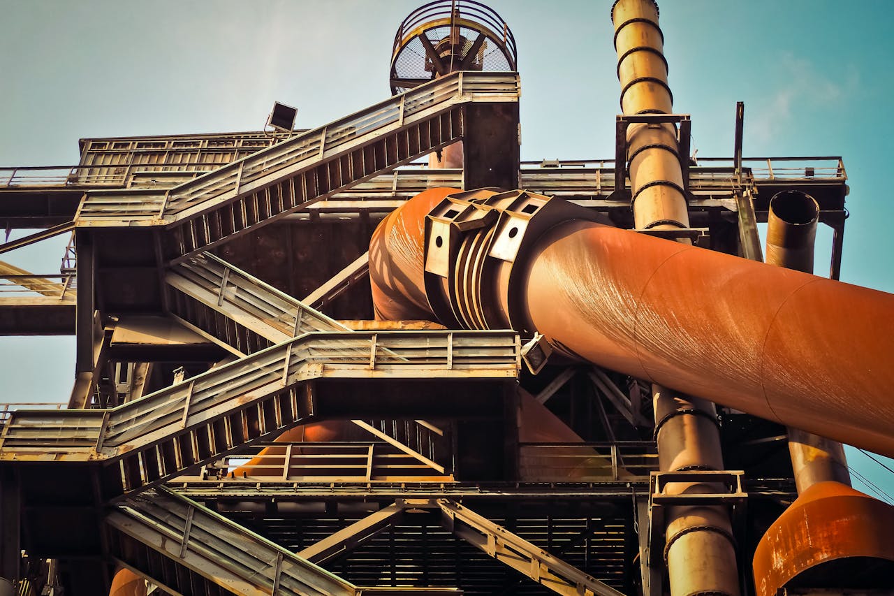 Close-up view of a rusty industrial structure with large pipes and steel framework, showcasing industrial decay.